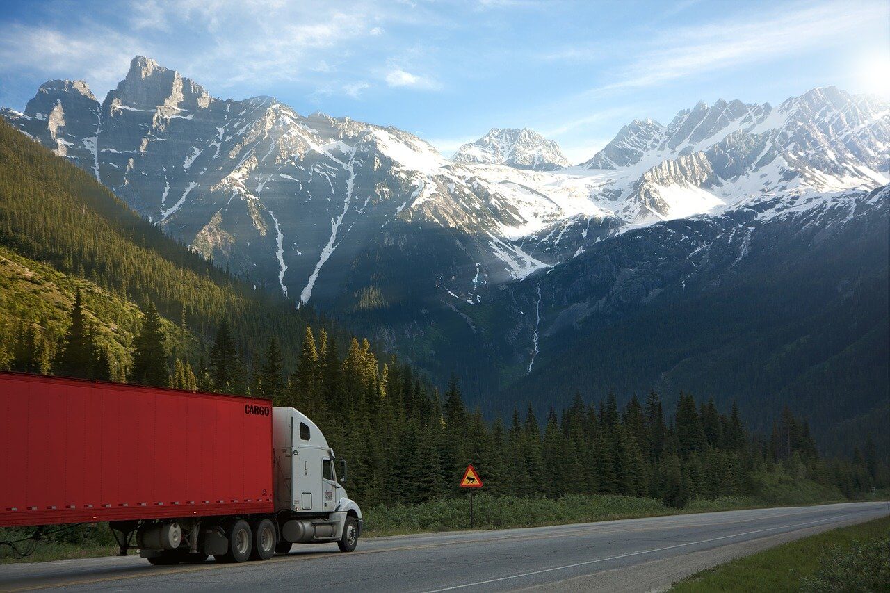 big rig truck on road with mountains in background