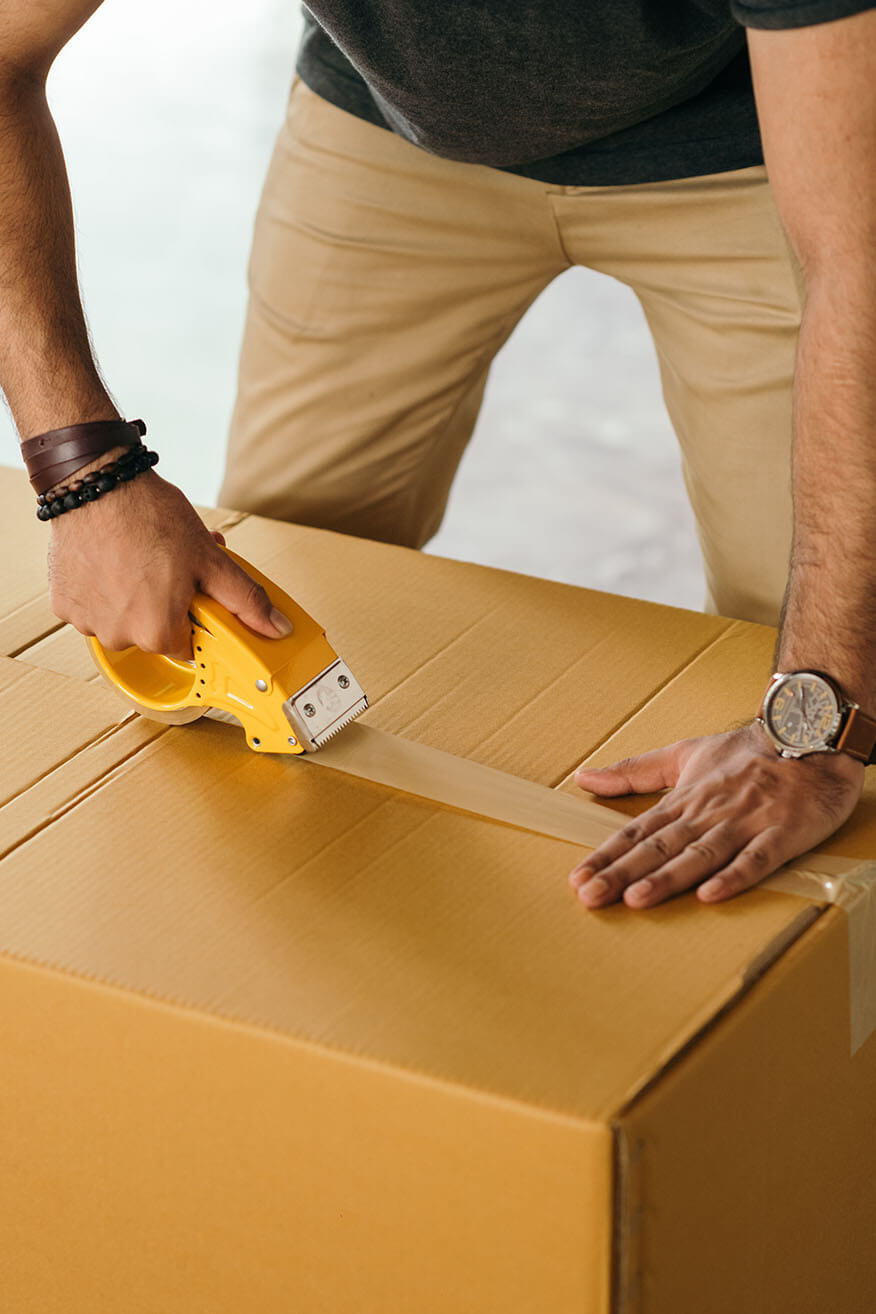 person taping a shipping box